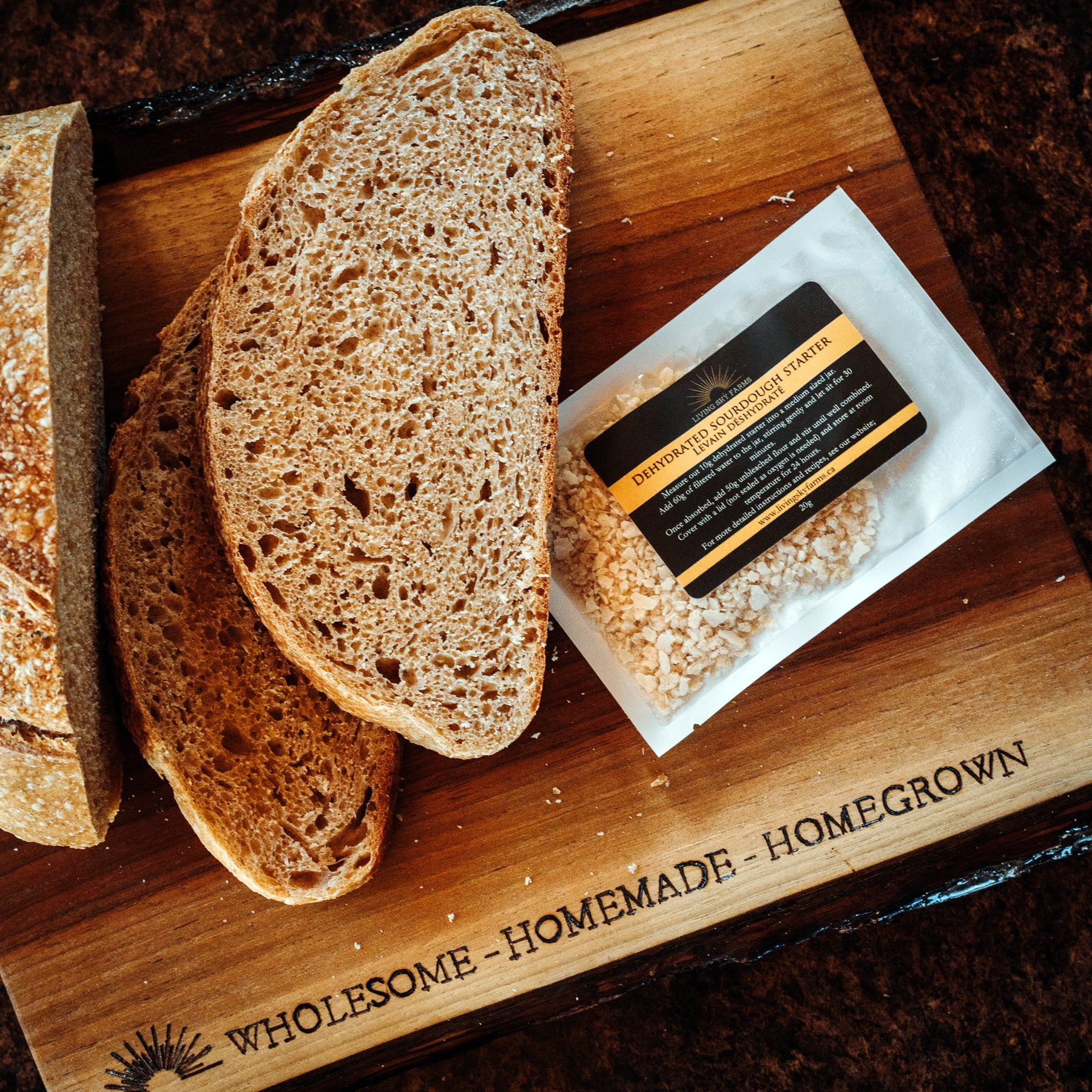 Living Sky Farm's Dehydrated Sourdough Starter with Sourdough bread on a wooden cutting board.